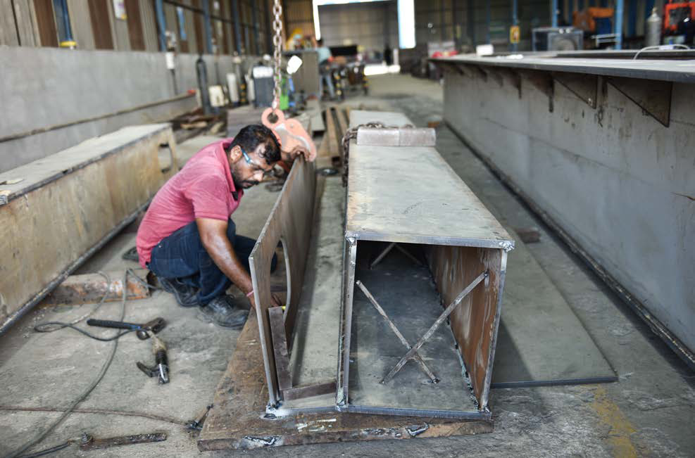 Fabricator shaping a stainless steel box section in the workshop