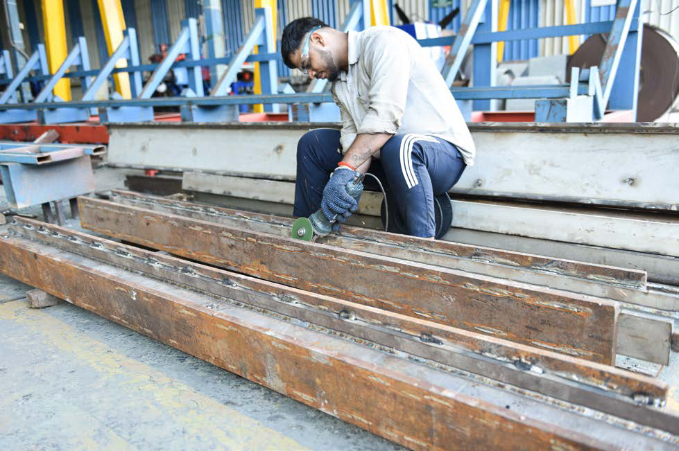 Operator grinding a fabricated stainless steel member